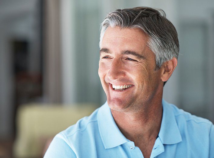 Man laughing with flawless smile after replacing missing teeth