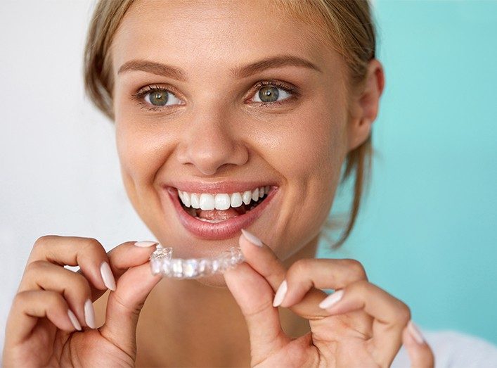 Woman holding a clear aligner tray