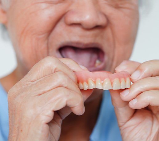 Woman putting in dentures