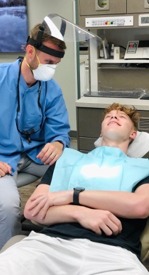 Dentist talking to smiling dental patient