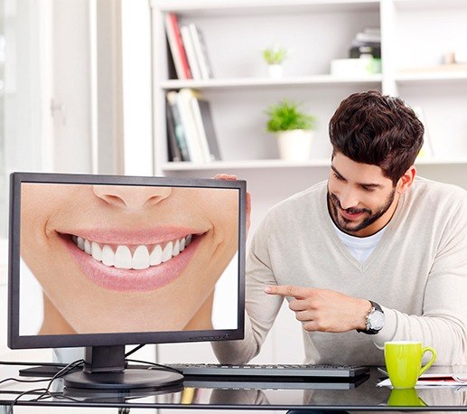 Man pointing to virtual smile design on computer screen