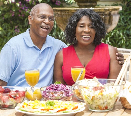 man and woman sitting at a table with food