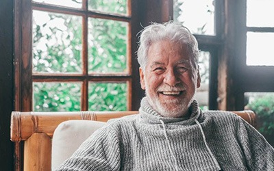 a mature man smiling with his new dentures