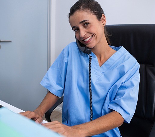 Smiling dental team member answering phone