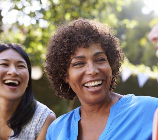Group of friends laughing after dental implant tooth replacement