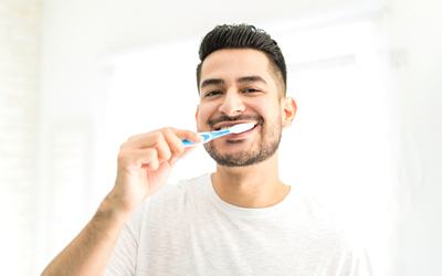 a person smiling and brushing their teeth