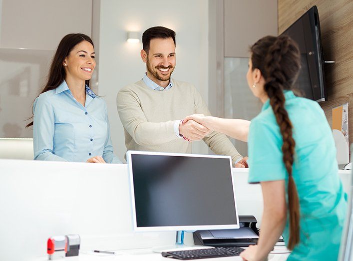 Man and woman checking in at dental office