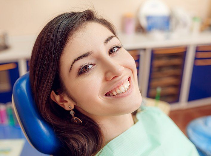 Woman in dental chair smiling during preventive dentistry visit