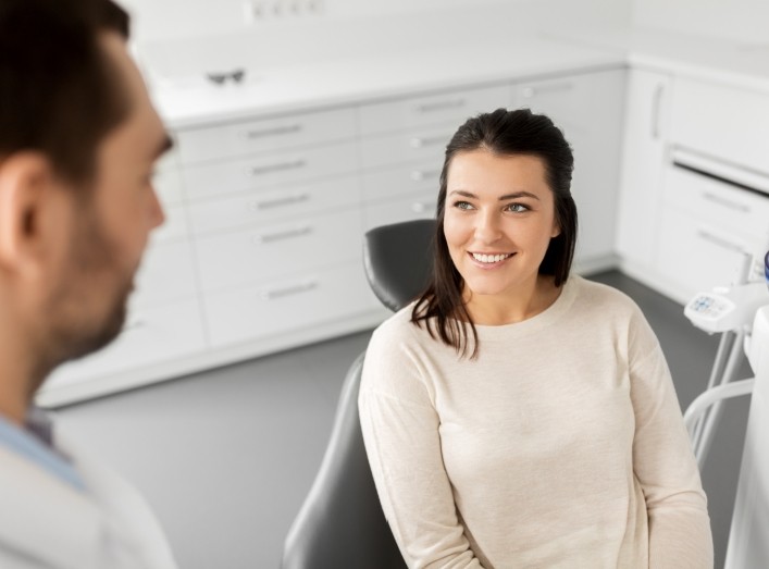 Woman smiling at dentist riding dental services