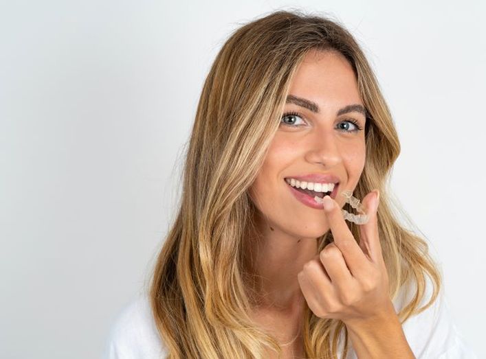 Beautiful woman holding Smile Shapers aligner