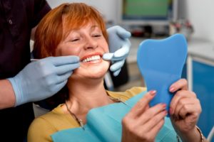 woman at the dentist smiling with her dental implants