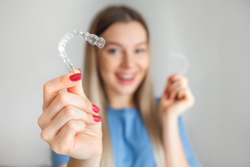young woman holding clear aligners