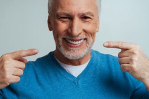 Older man smiling with dentures. 