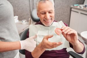Man smiling while getting new dentures