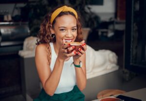 Woman smiling and enjoying a cup of coffee.